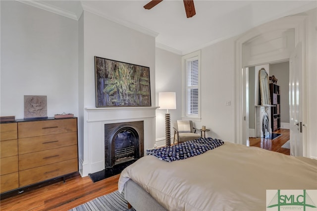 bedroom with ceiling fan, crown molding, and hardwood / wood-style flooring