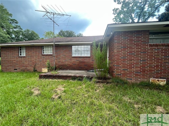 view of property exterior with a lawn and a patio area