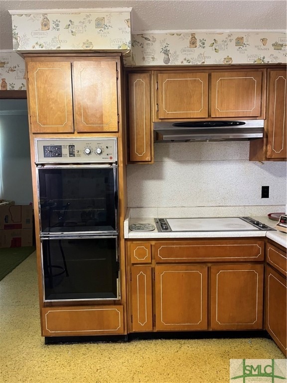 kitchen featuring double oven, white gas stovetop, and a textured ceiling