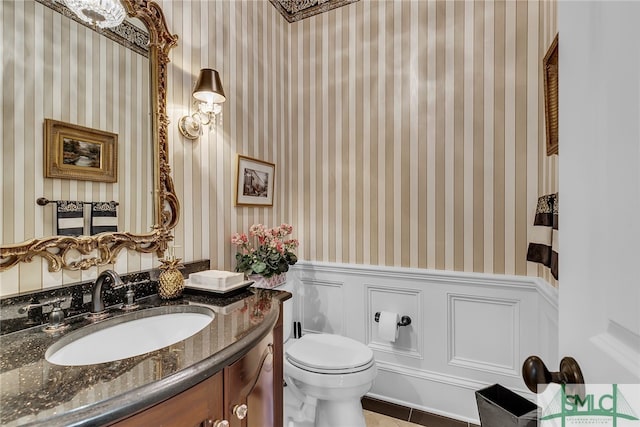 bathroom featuring tile floors, large vanity, and toilet