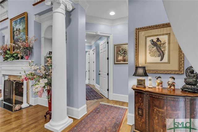 hallway featuring ornamental molding, decorative columns, and hardwood / wood-style floors