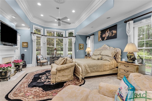 carpeted bedroom with crown molding, ceiling fan, and a raised ceiling