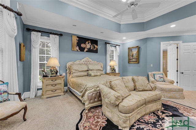 carpeted bedroom featuring a tray ceiling, crown molding, and ceiling fan