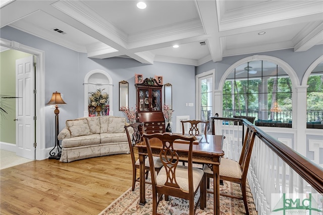 dining area featuring beamed ceiling, coffered ceiling, light wood-type flooring, and crown molding