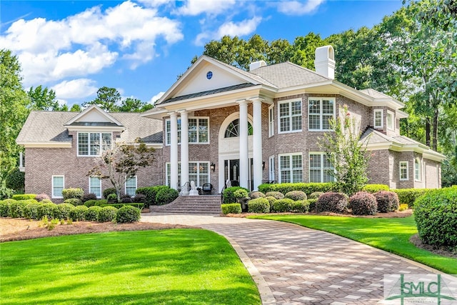 neoclassical / greek revival house featuring a front lawn