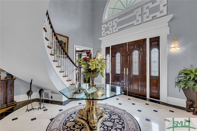 entryway featuring a towering ceiling, tile flooring, and a healthy amount of sunlight