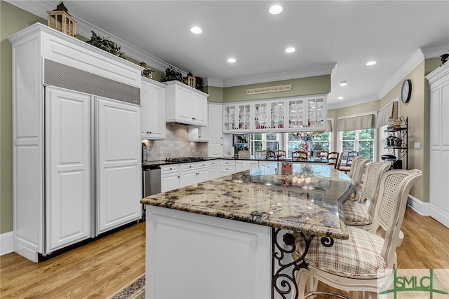 kitchen with light hardwood / wood-style floors, white cabinets, and crown molding