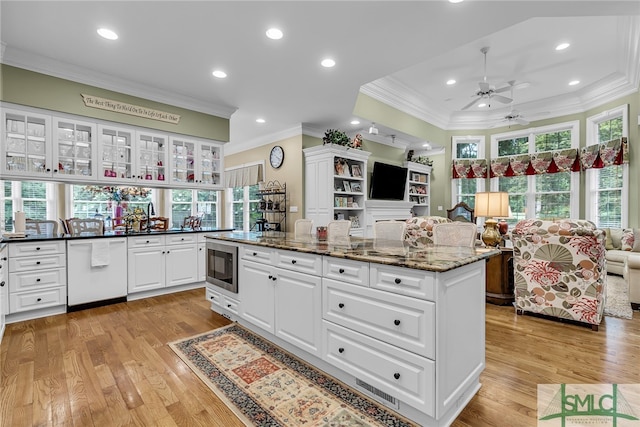 kitchen featuring ceiling fan, light hardwood / wood-style flooring, stainless steel microwave, white dishwasher, and white cabinets