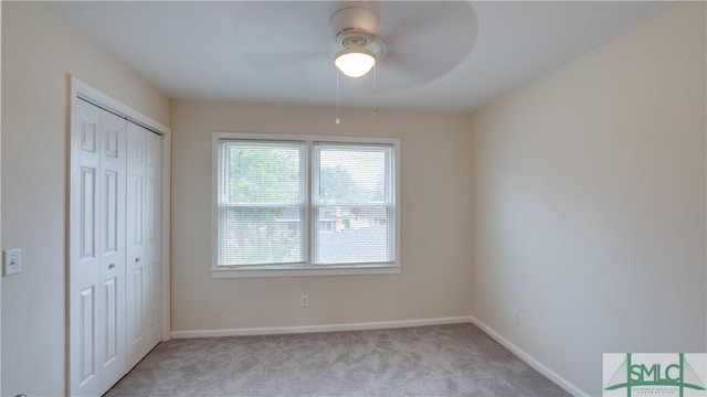 unfurnished bedroom with a ceiling fan, baseboards, a closet, and light colored carpet