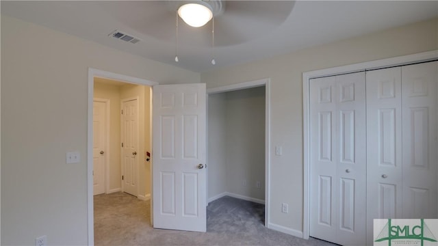 unfurnished bedroom featuring baseboards, visible vents, a ceiling fan, carpet floors, and a closet