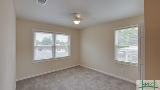 empty room featuring baseboards, carpet flooring, visible vents, and a healthy amount of sunlight