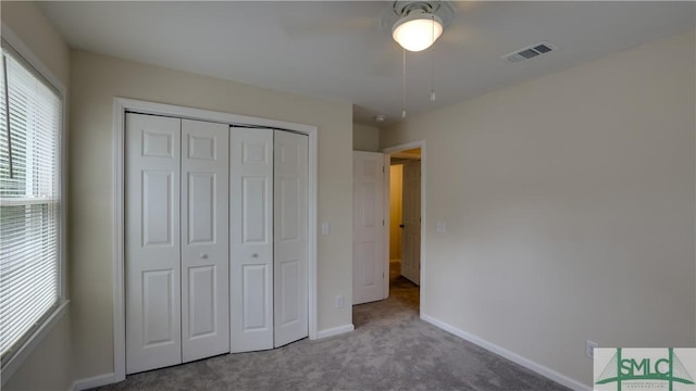 unfurnished bedroom featuring ceiling fan, carpet floors, visible vents, baseboards, and a closet