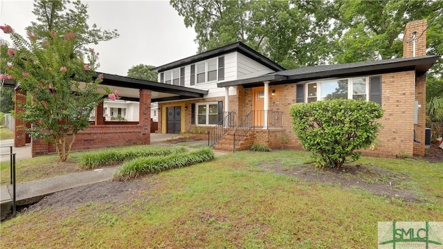 view of front of house with brick siding, a chimney, and a front lawn