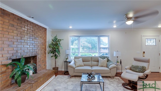 living room featuring a healthy amount of sunlight, a brick fireplace, crown molding, and wood finished floors