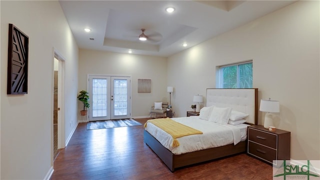 bedroom with dark wood-style flooring, baseboards, access to exterior, french doors, and a tray ceiling