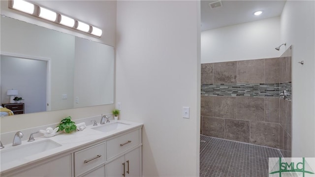 bathroom featuring double vanity, visible vents, a sink, and walk in shower