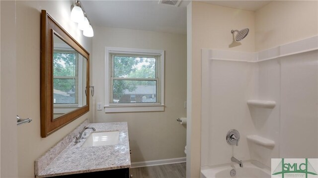 full bathroom featuring shower / tub combination, wood finished floors, visible vents, vanity, and baseboards