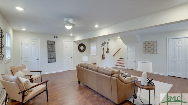 living room featuring recessed lighting, visible vents, dark wood finished floors, and stairs