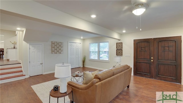 living area with baseboards, wood finished floors, and recessed lighting