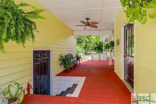 wooden terrace featuring ceiling fan and a porch