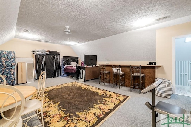 interior space featuring bar area, lofted ceiling, light carpet, and a textured ceiling