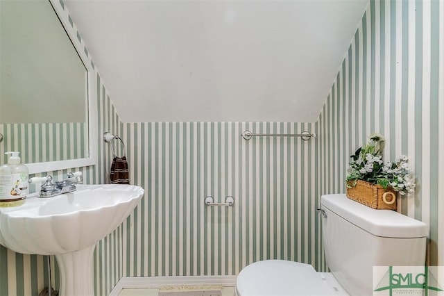 bathroom featuring vaulted ceiling and toilet