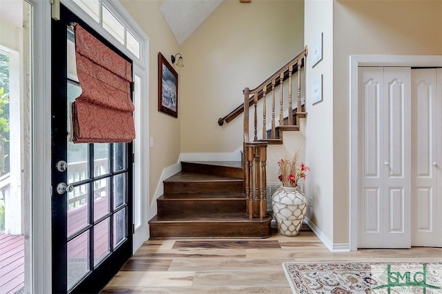 interior space featuring french doors, lofted ceiling, light hardwood / wood-style flooring, and a healthy amount of sunlight