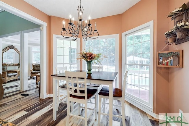 dining space featuring hardwood / wood-style floors and a notable chandelier