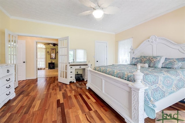 bedroom featuring dark hardwood / wood-style flooring, ceiling fan, french doors, and a textured ceiling