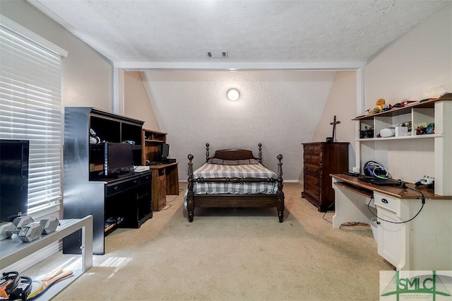 carpeted bedroom featuring a textured ceiling and vaulted ceiling