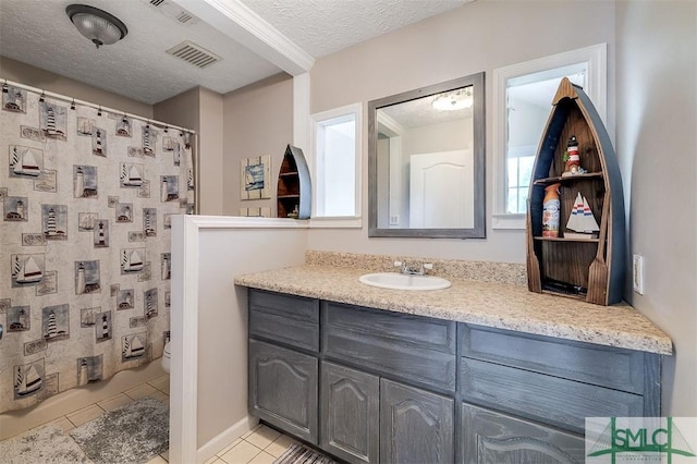 bathroom featuring vanity, tile patterned floors, toilet, a textured ceiling, and walk in shower