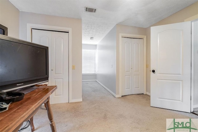 carpeted home office featuring a textured ceiling