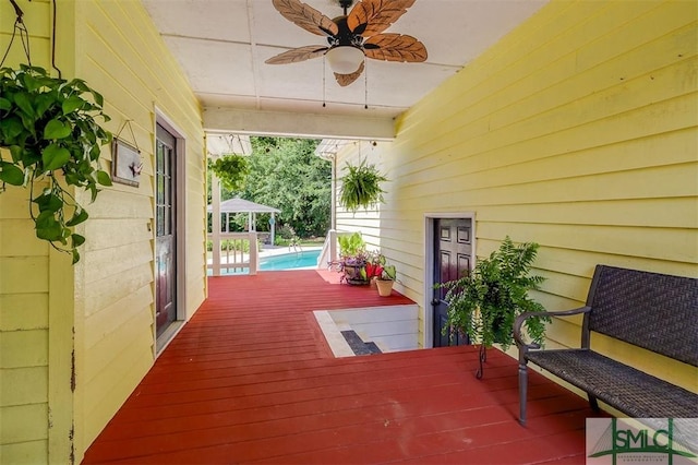 wooden terrace featuring a gazebo and ceiling fan