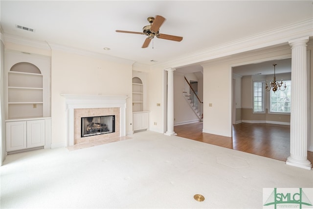 unfurnished living room with a fireplace, built in shelves, ceiling fan with notable chandelier, and crown molding