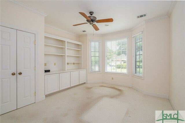 carpeted spare room with ceiling fan and crown molding