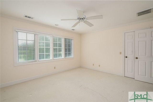 empty room with crown molding, ceiling fan, and light colored carpet