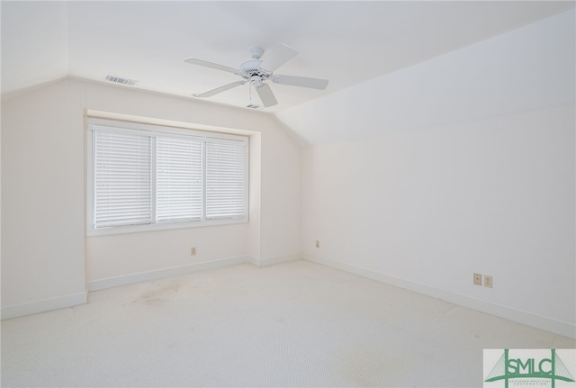 carpeted spare room with ceiling fan and lofted ceiling