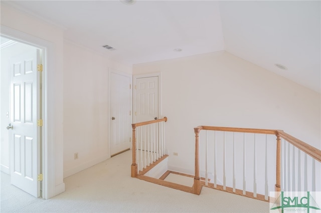 interior space featuring light carpet, crown molding, and lofted ceiling