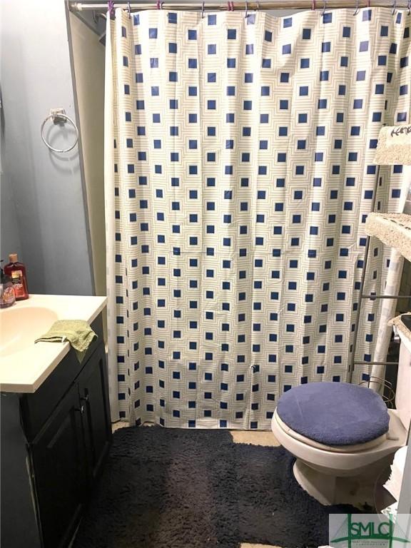 bathroom featuring vanity, curtained shower, and toilet