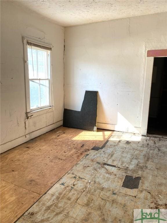 unfurnished room featuring a textured ceiling