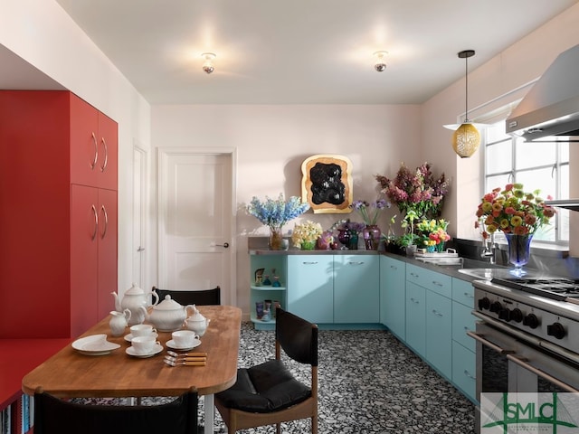 kitchen featuring wall chimney range hood, decorative light fixtures, blue cabinets, and high end stove