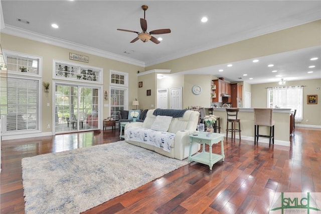 living room with dark wood-type flooring, ceiling fan, and ornamental molding