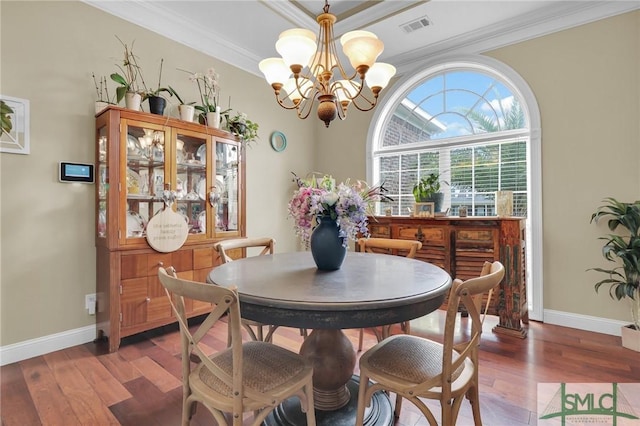 dining space featuring a notable chandelier, wood-type flooring, and ornamental molding