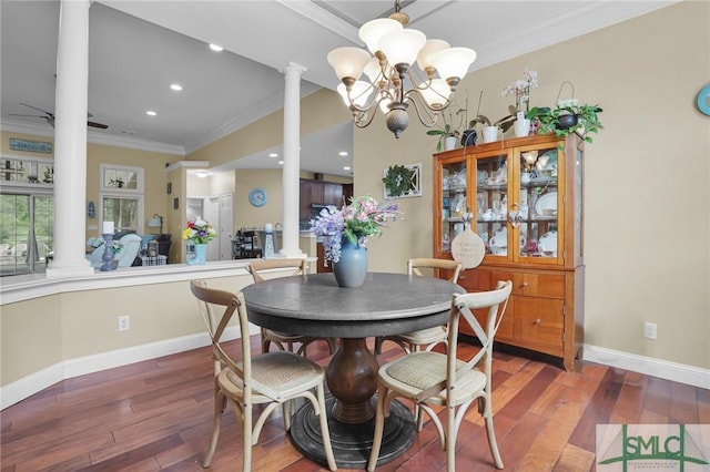 dining area featuring dark wood-type flooring, ornamental molding, an inviting chandelier, and ornate columns