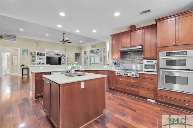 kitchen featuring tasteful backsplash, dark hardwood / wood-style floors, kitchen peninsula, a kitchen island, and stainless steel appliances