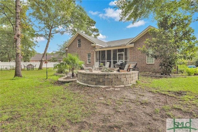 rear view of property with a yard, a patio area, and a sunroom