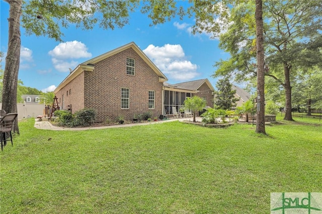 back of property with a sunroom and a yard