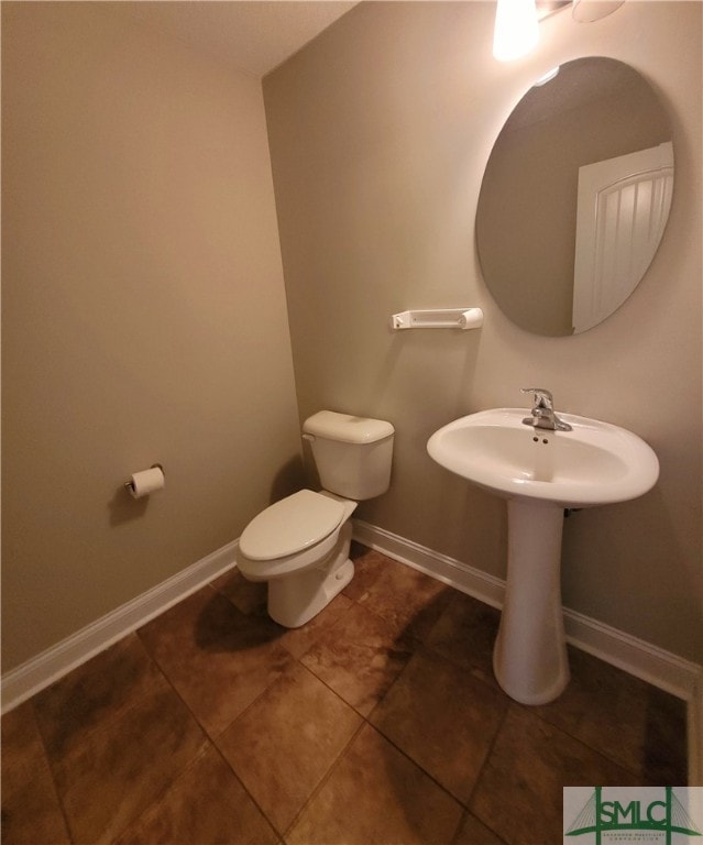 bathroom with toilet and tile patterned floors