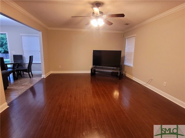 living room with dark wood-type flooring, ornamental molding, and ceiling fan