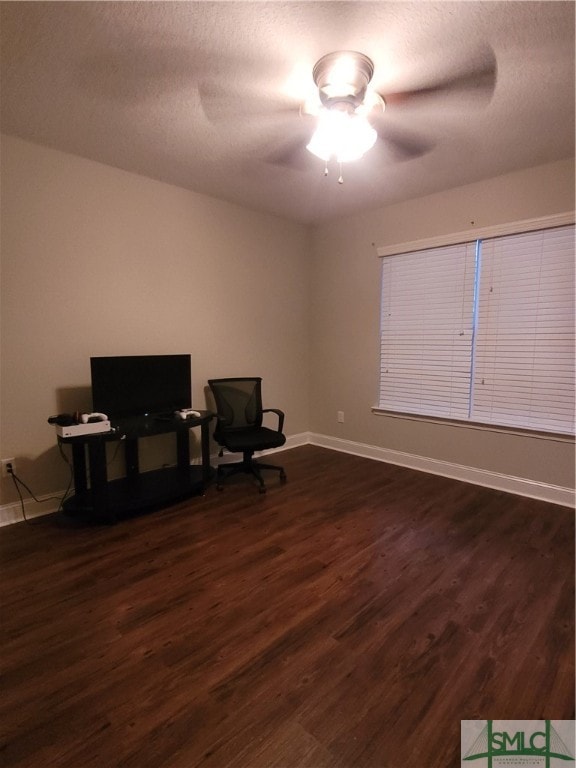 living area featuring ceiling fan and dark wood-type flooring